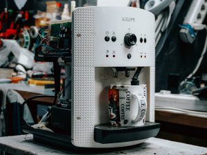 Cafetière électrique en cours de réparation sur un établi, composants électroniques apparents