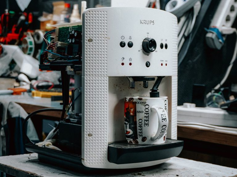 Cafetière électrique en cours de réparation sur un établi, composants électroniques apparents