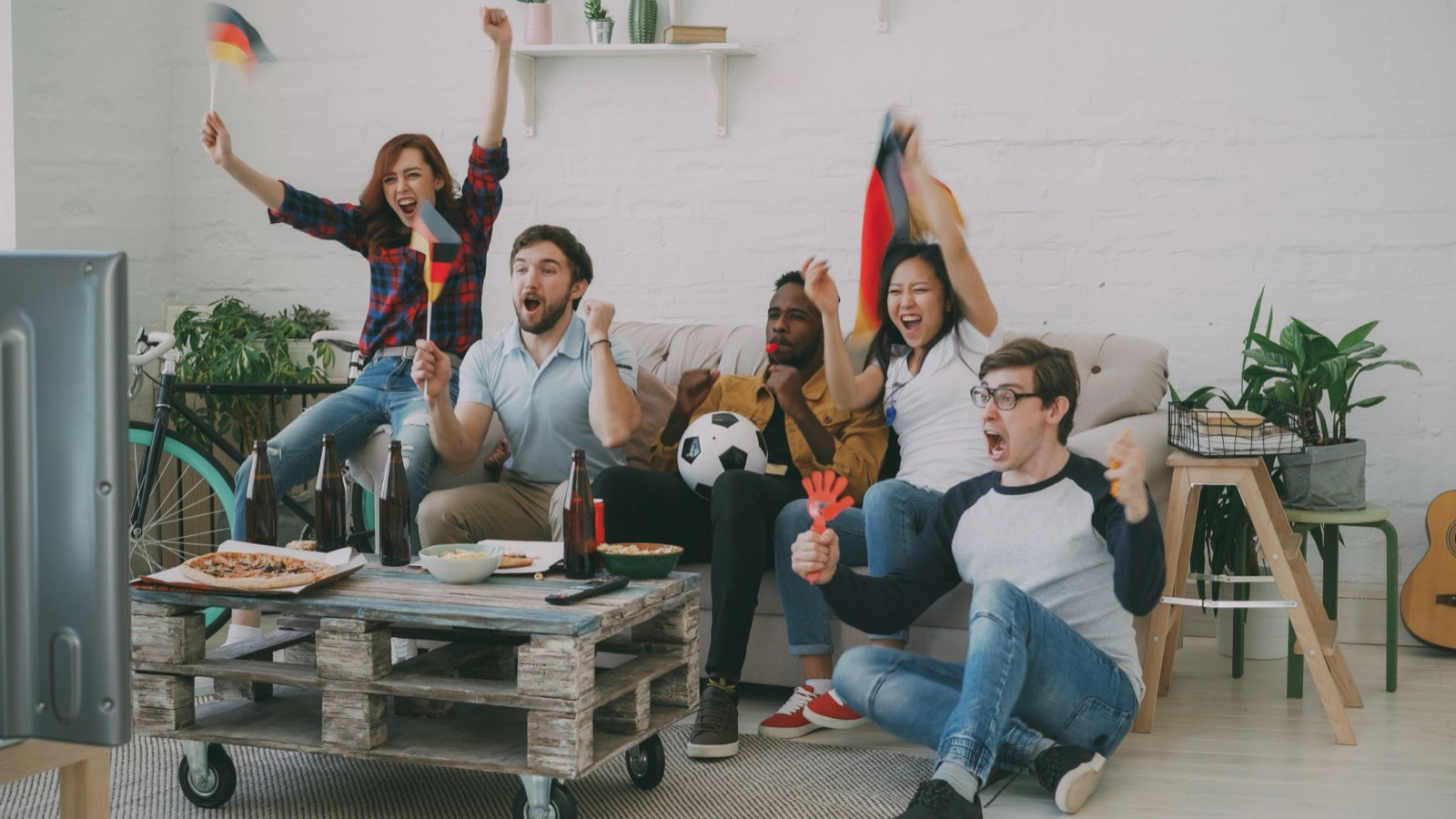 Groupe d'amis réunis devant la télévision pour regarder un match de football