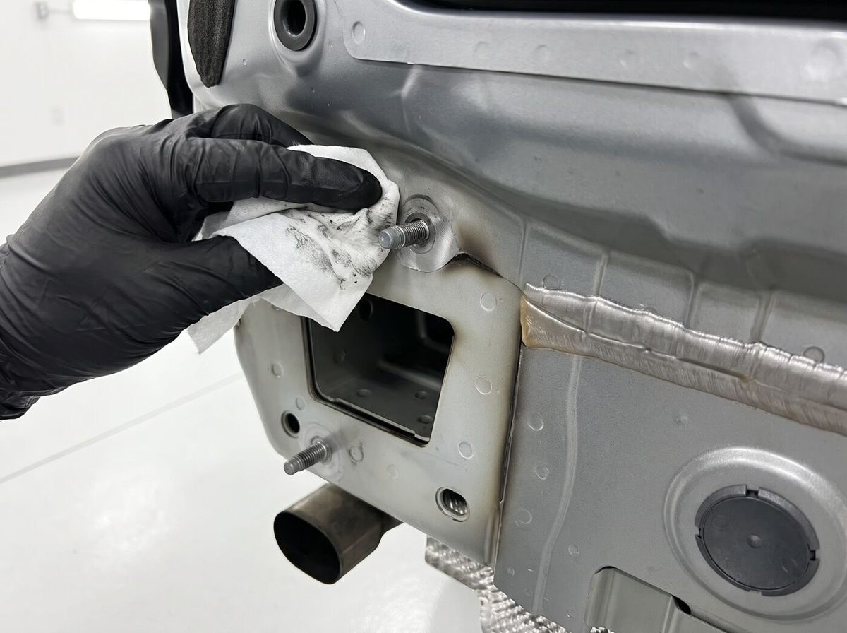 Technicien préparant le point d'ancrage de l'attelage sur le châssis du véhicule
